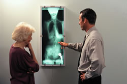 doctor examines x-ray with patient